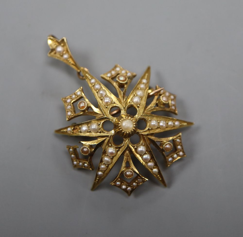 An Edwardian 15ct and graduated seed pearl set starburst pendant brooch, 32mm, gross 6.4 grams.